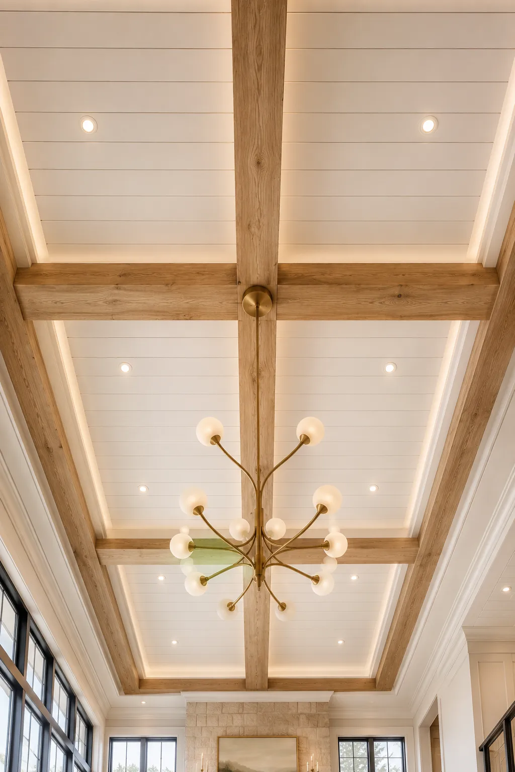 Elegant white shiplap ceiling framed with oversized natural oak beams, recessed lighting, hidden LED cove lighting, modern brass statement chandelier, luxury great room ceiling design, timeless architectural detail, premium farmhouse inspired interior, sophisticated beam and shiplap ceiling ideas for upscale homes