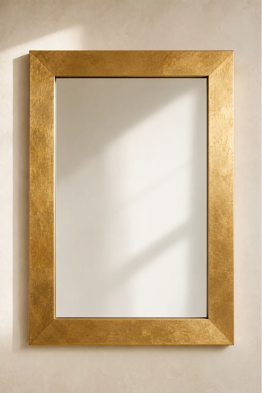 Gold leaf mirror frame featuring a luxurious rectangular wall mirror finished with authentic hand applied gold leaf that creates rich metallic texture and elegant reflections. Mounted on a warm neutral wall, this DIY mirror frame is perfect for luxury home décor, glamorous bathrooms, Art Deco interiors, fireplace mirrors, elegant bedroom styling, and designer wall mirror inspiration.
