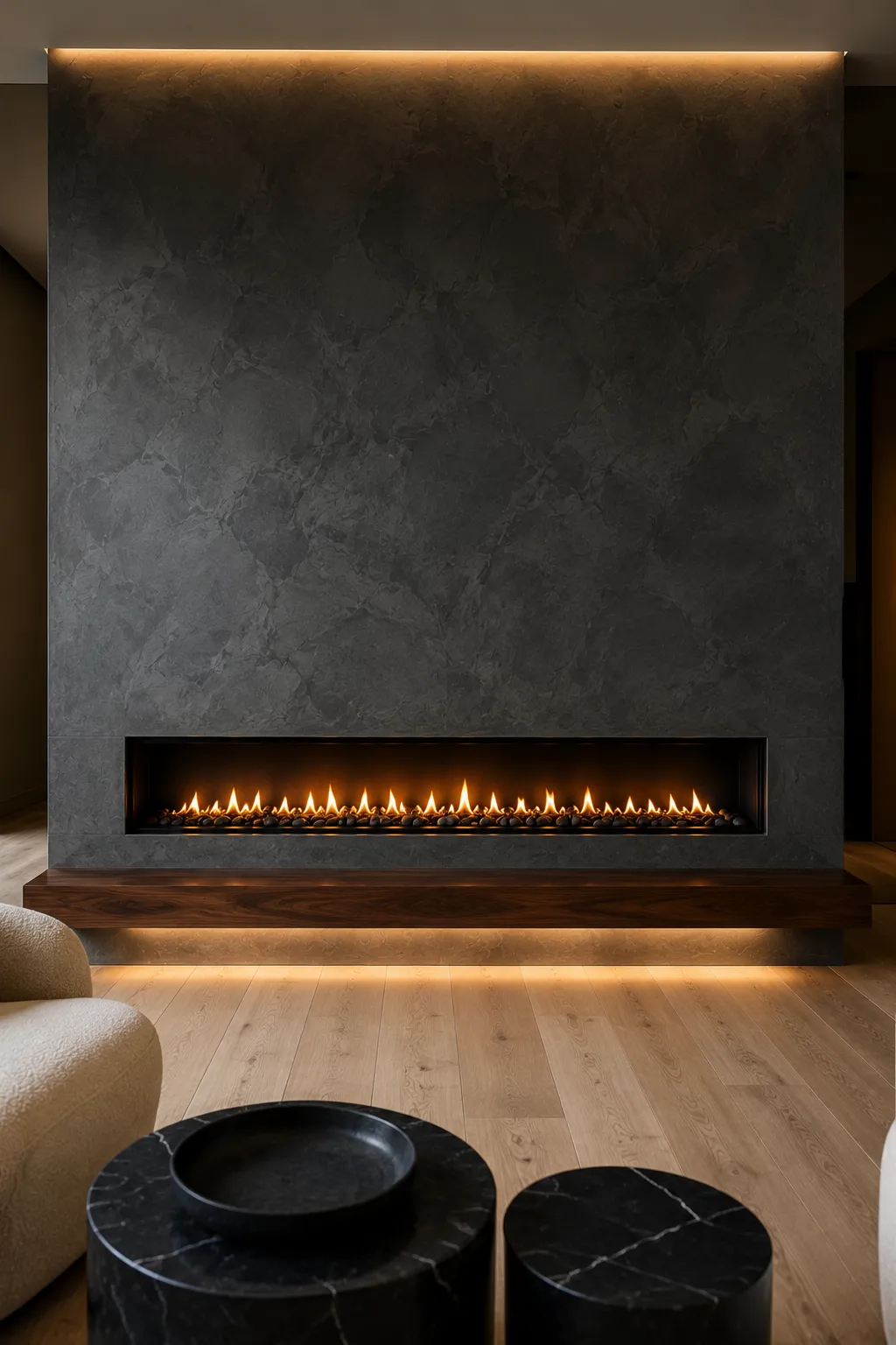 Bold charcoal fireplace feature wall with a sleek linear fireplace, textured dark plaster finish, floating walnut media cabinet, concealed warm LED lighting, neutral contemporary furniture, and a luxury modern living room with dramatic architectural design.