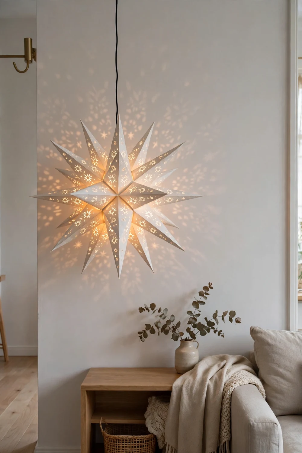 Paper star lantern hung low in a Scandinavian room Folded white paper star lantern glowing at eye level in a Scandinavian living room