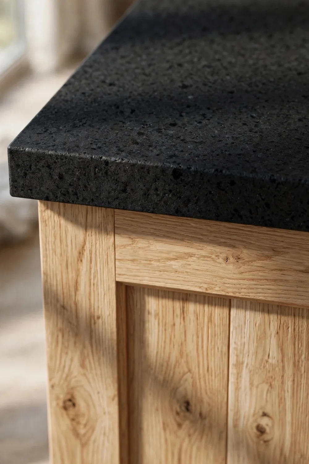 White oak and black kitchen island with honed black stone countertop