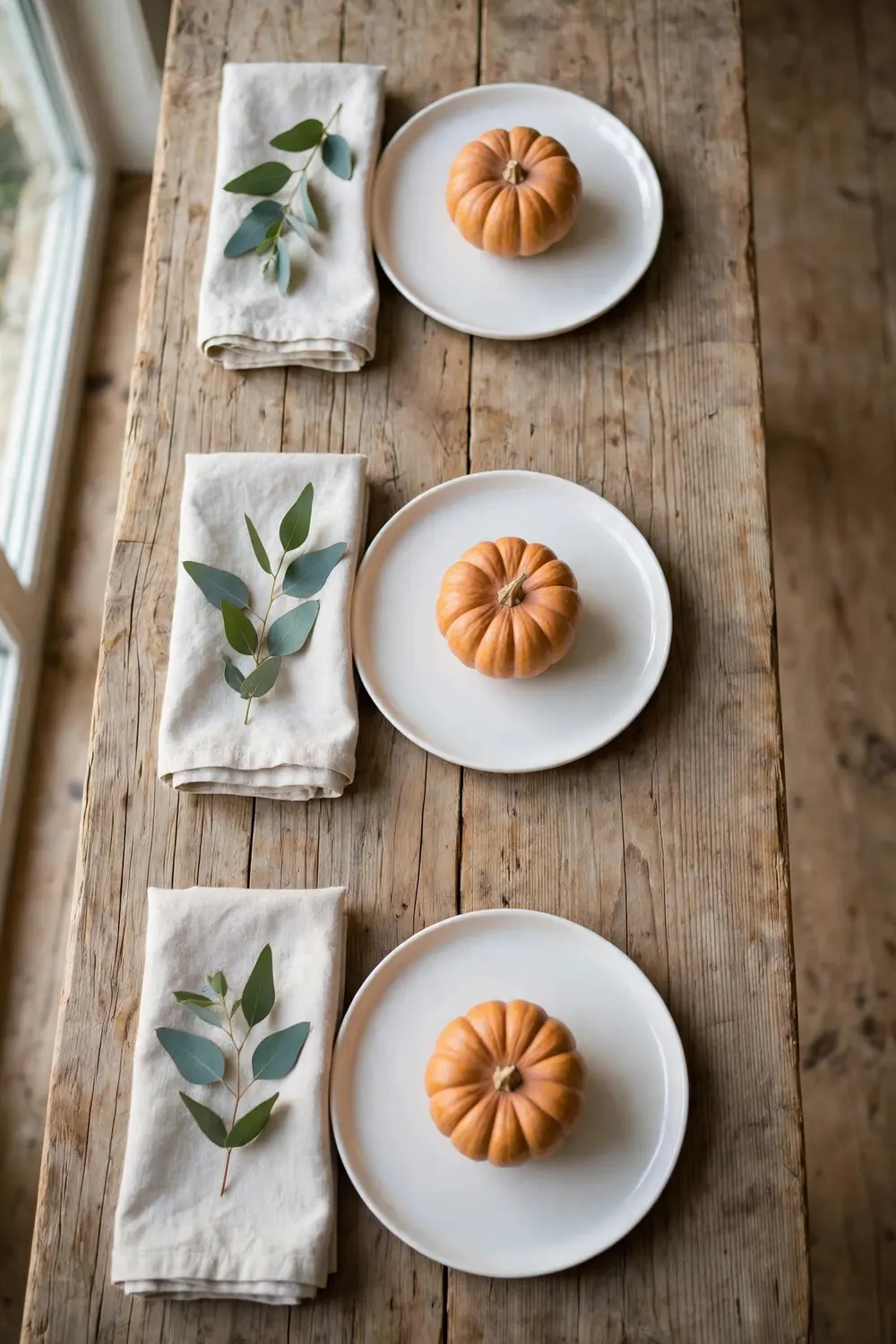 Minimalist Thanksgiving place setting with single pumpkin on white plate