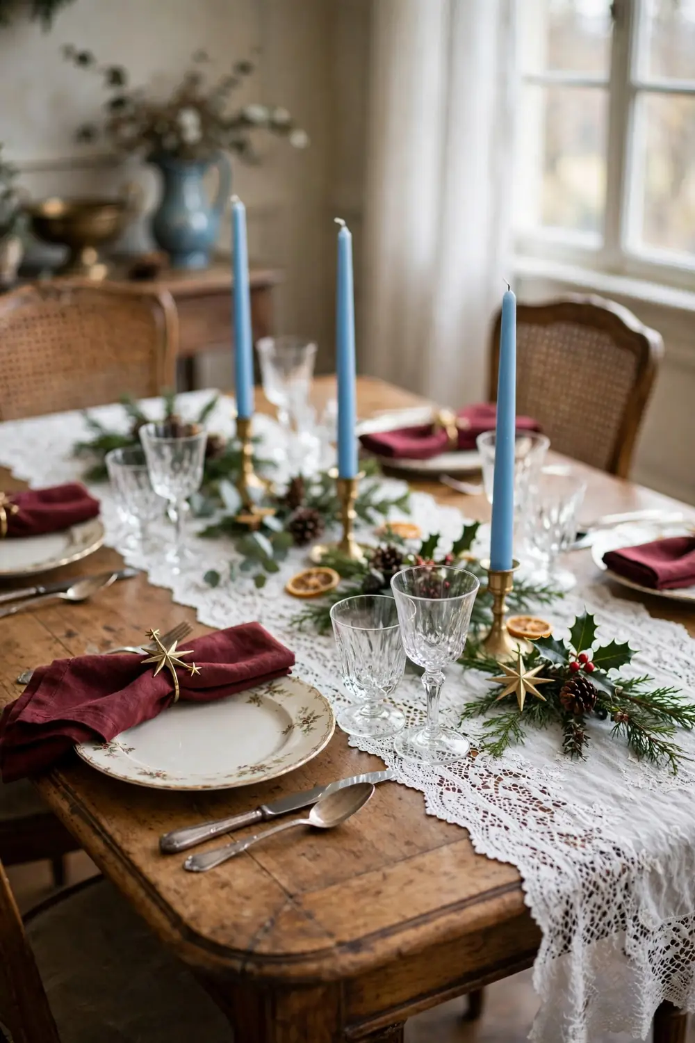 Heirloom lace runner with sky blue candles Christmas table White lace table runner with sky blue taper candles and burgundy napkins with brass star rings