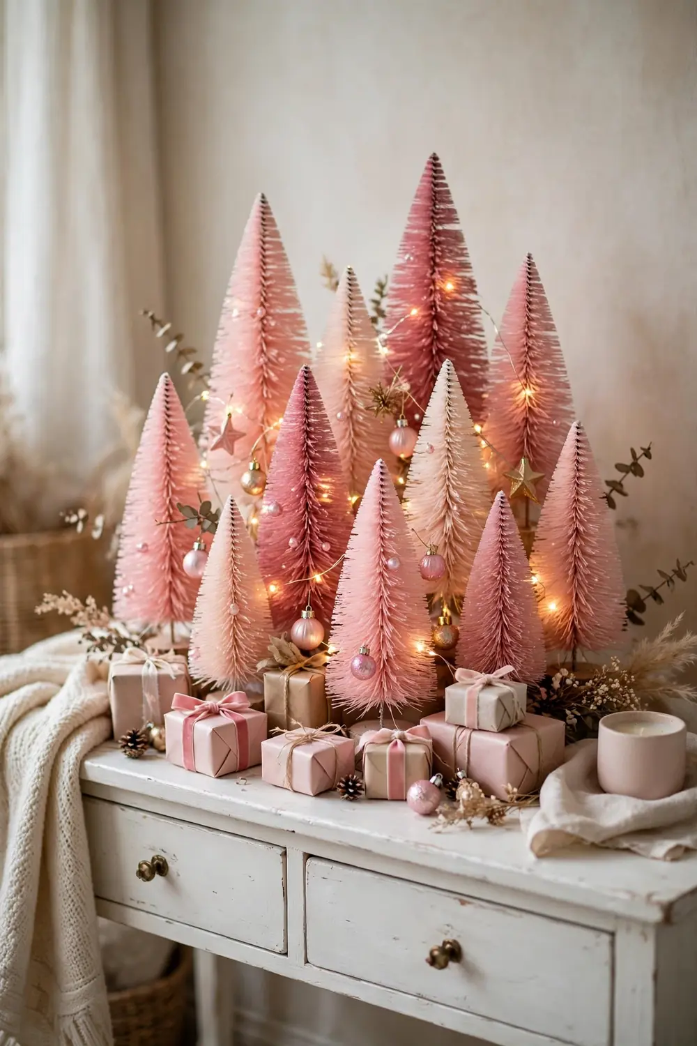 Small pink christmas tree vignette on a side table with tiny ornaments and fairy lights