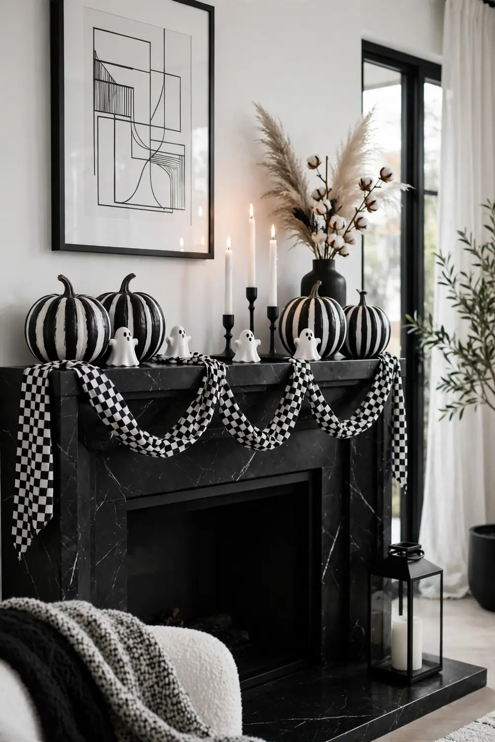 Halloween mantel decor ideas: elegant black and white monochrome mantel with striped pumpkins and checkered garland